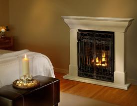 Portrait StoneFire by Valor with white surround and mantel in a bedroom with a table and candle