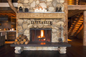 stone fireplace with wooden mantel and bench