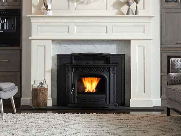 Accentra Pellet Stove Insert-Black facing - chair on each side - wooden white surround and mantel